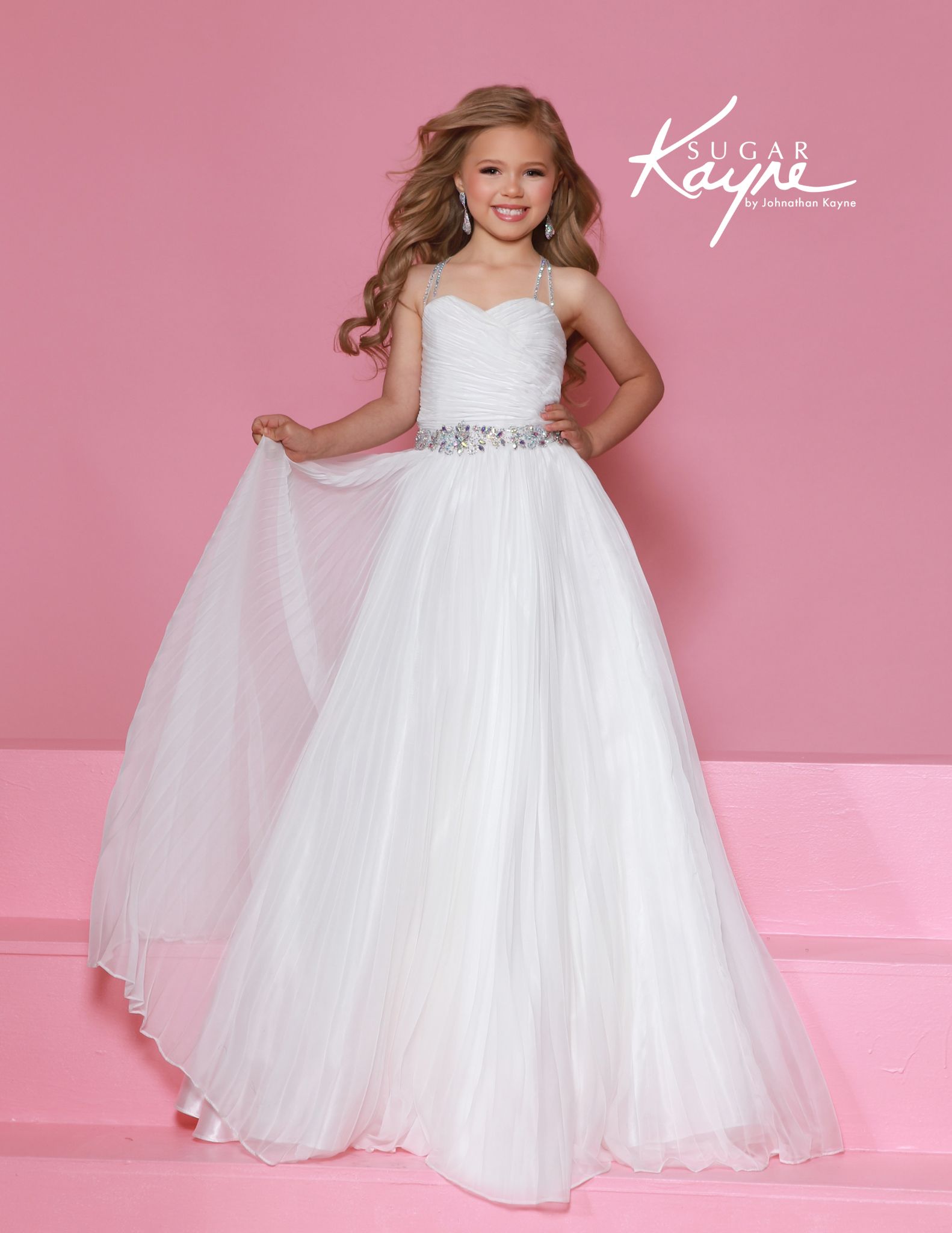 White pleated gown for girls with sweetheart neckline, jeweled belt, and sparkling straps, ideal for pageants and flower girl looks.